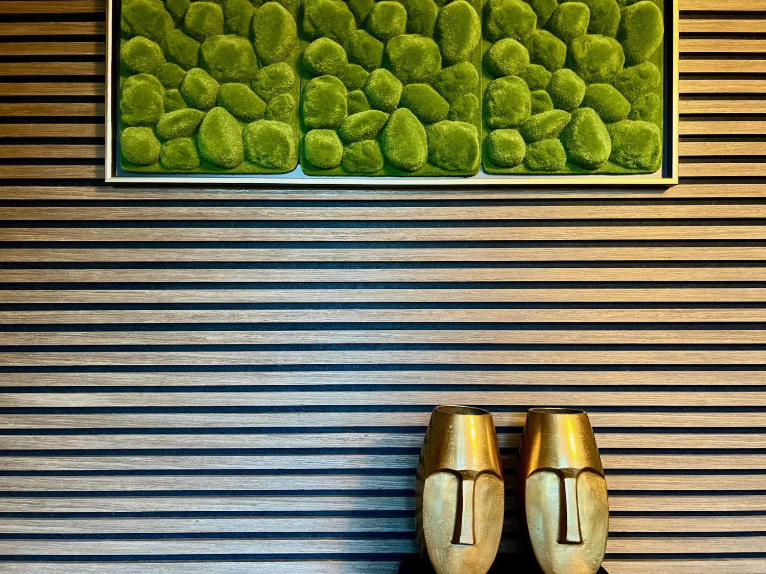 Zwego GmbH – dekorative schwarz-goldene Wand mit grüner Malerei darauf